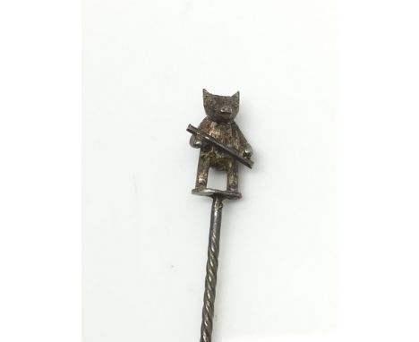 A Victorian silver stickpin in the form of a bear holding a stick.