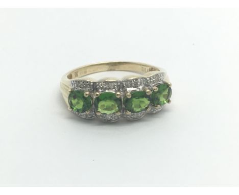 A 9carat gold ring set with four Oval cut green stones. ring size O-P