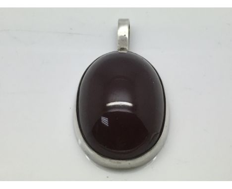 A silver and cherry amber pendant, approx 41mm x 23mm.