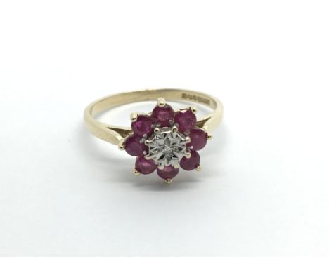 A 9carat gold ring setvwith a flower pattern of ruby and central diamond ring size N-O