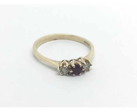 A 9carat gold ring set with a ruby flanked by two diamond ring size L-M