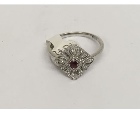 A 18 ct white gold ring of Art Deco form inset with ruby and diamond chips .size M