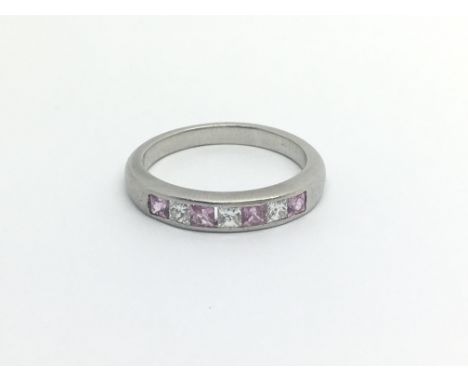 A white metal possible unmarked platinum ring set with pink sapphire and diamonds ring size O