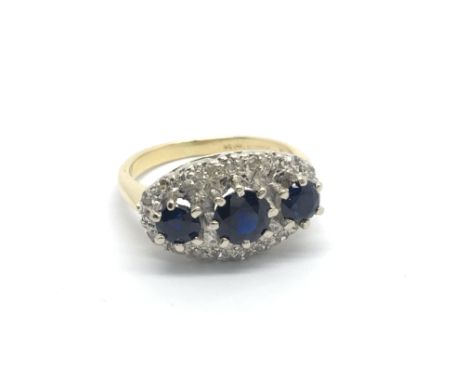 An 18carat gold ring set with three sapphire and a pattern of diamonds ring size H-I