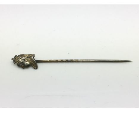 An antique silver gilt stickpin, the top decorated with the head of Queen Victoria.