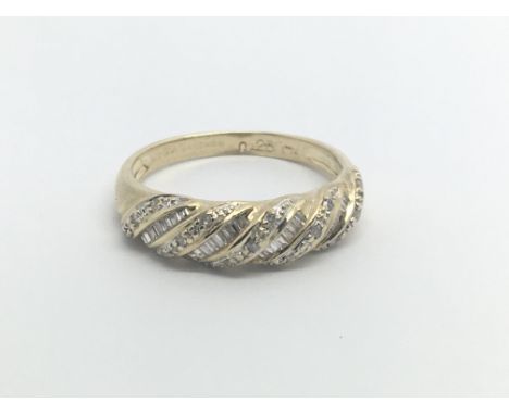 A 9carat gold ring set with with alternating rows of diamond baguette and brilliant cut diamonds. Ring size O