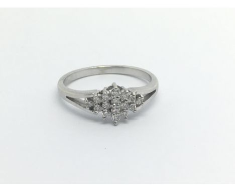 An unmarked white gold ring set with a geometric pattern of diamonds ring size O