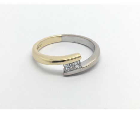 A modern design white and yellow gold ring set with two princess  cut diamonds 0.20 of a carat ring size O