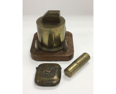 Three trench art items comprising a table lighter, vesta case and one other lighter.