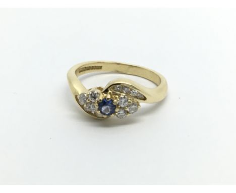 An 18carat gold ring set with a blue Sapphire flanked by brilliant cut diamonds ring size K-L