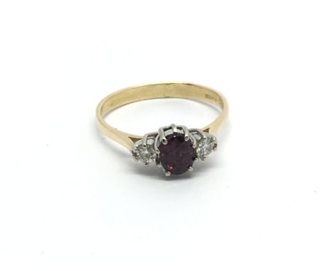 An 18carat gold ring set with an almandine garnet flanked by diamonds ring size Q