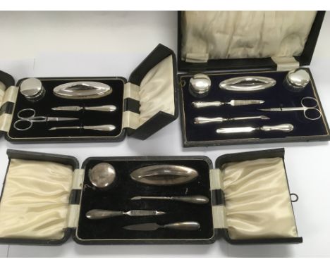 Three boxed silver manicure sets.