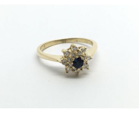 An 18carat gold ring set with a blue sapphire a diamonds in a flower head cluster ring size I-J