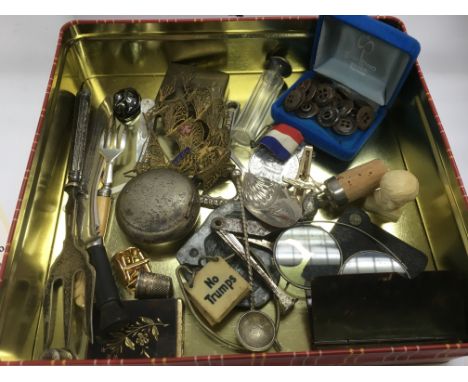 A tin of oddments including a letter opener, caddy spoon etc.