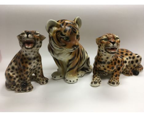 Three ceramic figures of big cats comprising a tiger cub and two leopards, approx heights 28.5cm, 24cm and 22cm.