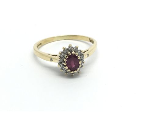 An 18carat gold ring set with a ruby and flanked by an oval of diamonds. ring size S.