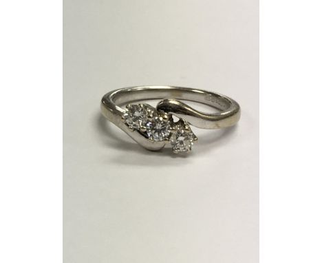 An 18 ct white gold diamond ring set with three brilliant cut diamonds . Size M