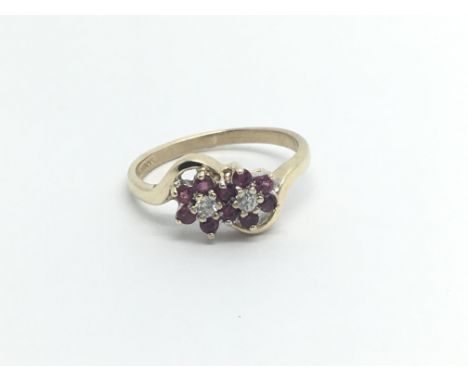 A 9carat gold ring set with  a pattern of ruby and diamonds in a double cluster ring size K-L 