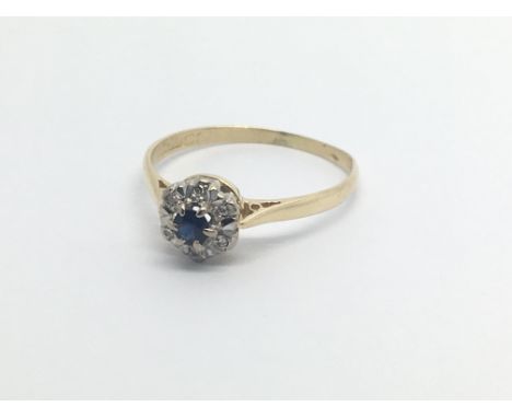 An 18carat gold ring set with a sapphire and a cluster of small diamonds ring size O-P.