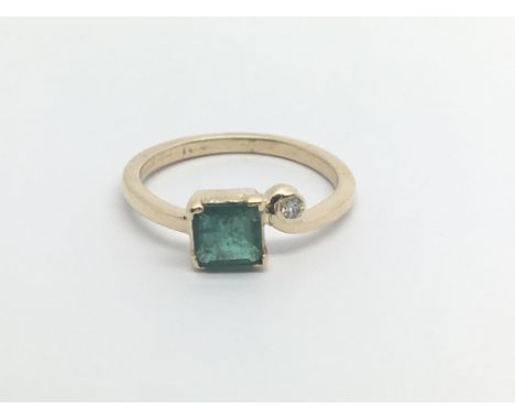 An 18carat gold ring set a Square Emerald the shank set with a single offset diamond ring size N-O