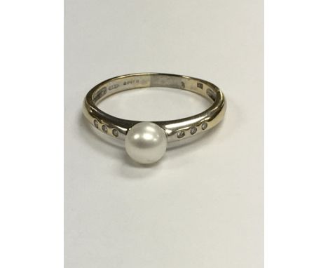 A 18 ct gold ring set with a single pearl the shanks inset with diamonds size S