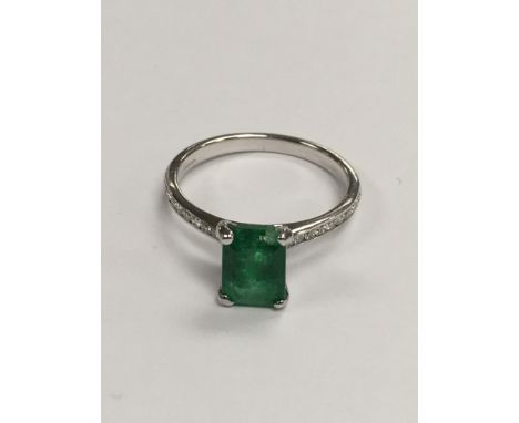 A 18 ct white gold ring inset with a square diamond the shank inset with diamonds .size N