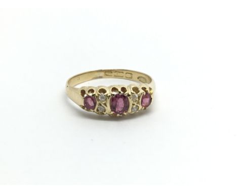 A Vintage 18carat gold ring set with three ruby and subdivided by small diamonds ring size N