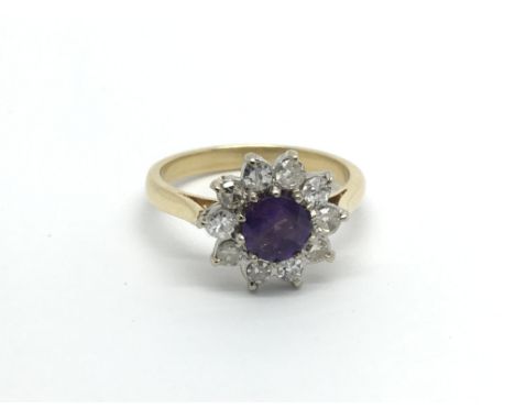 An 18carat gold ring set with amethyst flanked by diamonds ring size M