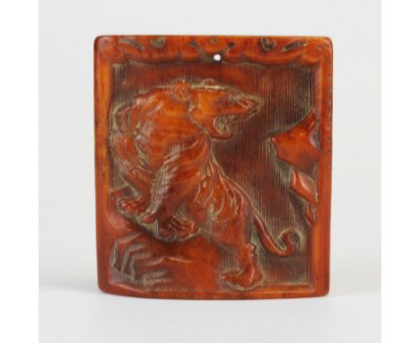 A Tibetan carved yak bone amulet of a tiger on a rock, 5 x 5cm.