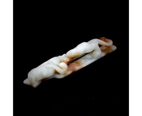 A Chinese celadon and russet jade amulet with dragon decoration, L. 13.4cm.