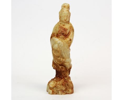A Chinese celadon and russet jade figure of the goddess Guanyin. H. 18 cms