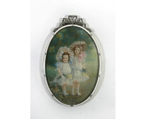 An Edward VII silver picture frameOf oval form, decorated with ribbon mount and white enamel detail, hallmarked London 1908, 