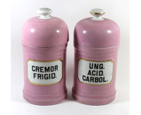 A pair of pink and gilt decorated ceramic apothecary jarsOf circular lidded form, one marked Cremor Frigid, the other Ung. Ac