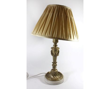 A 20th Century gilt metal and marble table lampFormed as a candlestick with leaf and garland mounts, raised on a circular bas