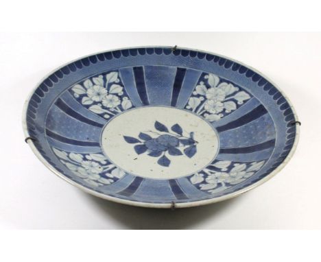 A Chinese blue and white wall chargerPainted with a central floral motifs inside floral panels, blue painted seal mark to bas