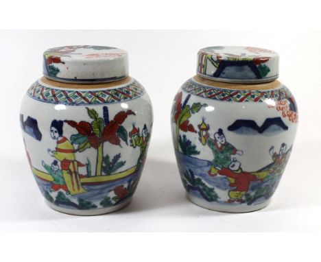 A pair of Chinese Wucai lidded jarsEach painted with figures in landscape, height 16cm, each bearing double ring mark to base
