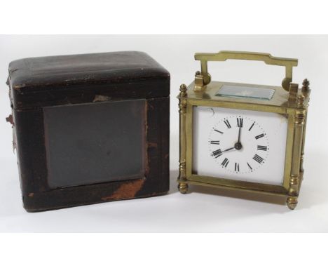A late 19th/early 20th Century brass cased carriage clock With white enamel dial with Roman numerals fitted with a looped fol