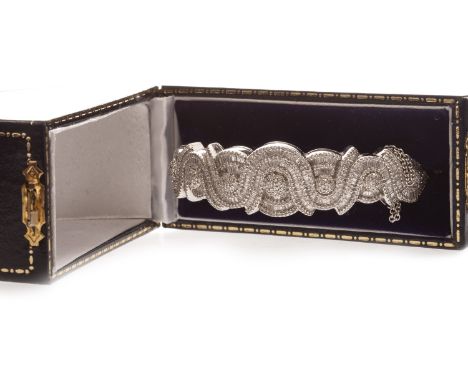 DIAMOND SET BANGLE, set with a row of convex diamond set circular sections with grain set stones, interspaced by waved rows o