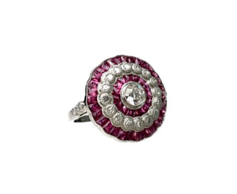 RUBY AND DIAMOND RING, the bezel 19mm in diameter, set with a central round brilliant cut diamond of approximately 0.25 carat