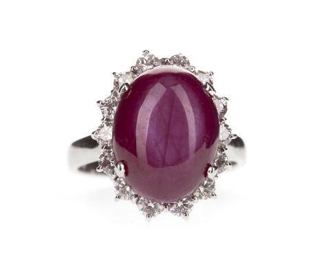 RUBY AND DIAMOND CLUSTER RING, set with a central oval cabochon ruby of approximately 10.50 carats within a diamond halo, in 