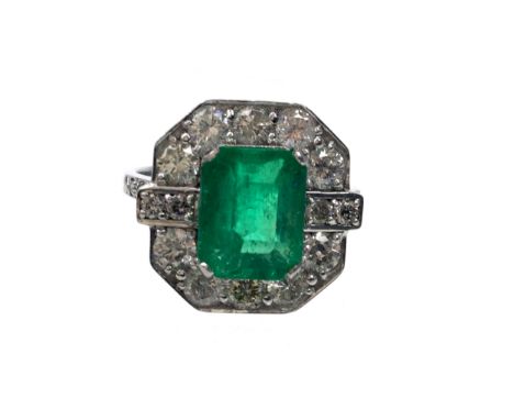 EMERALD AND DIAMOND RING, the octagonal bezel set with central step cut emerald bordered by round brilliant cut diamonds tota