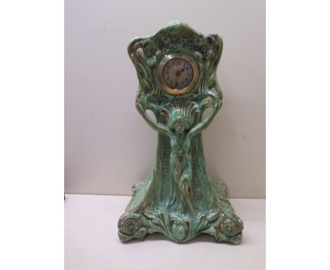 An Art Nouveau green glaze stone ware mantle clock - height 37cm - movement running, small chips to base and restorations to 