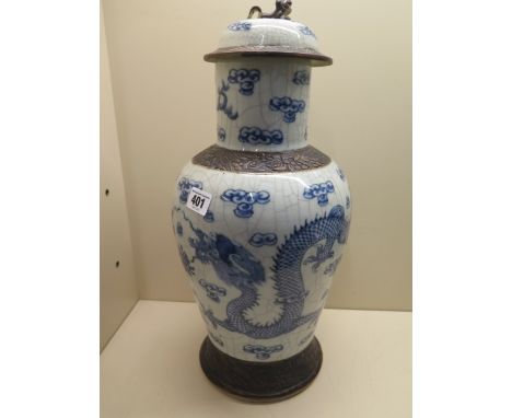 A Chinese early 20th century blue and white vase and cover well decorated with a pair of dragons chasing a pearl amongst clou