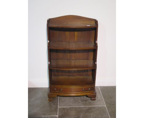 A 20th century solid mahogany three shelf waterfall bow front bookcase with drawer below standing on ogee shaped bracket feet