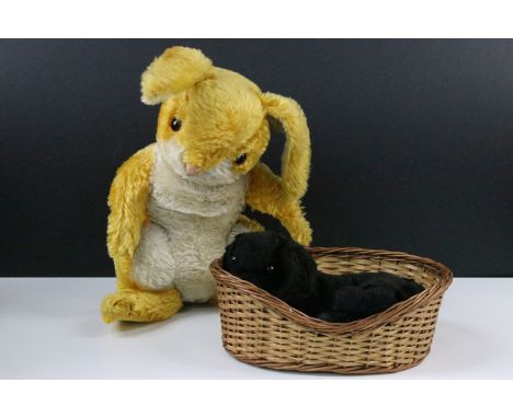 Two early Merrythought teddy bears to include black puppy dog in wicker basket with yellow bowtie around neck, with dark oran