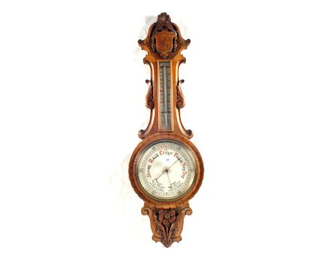 An Oak barometer carved with flowers and Coat of Arms