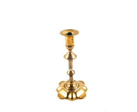 An 18th Century seamed Brass candlestick with knopped stem and petal base, 8" high