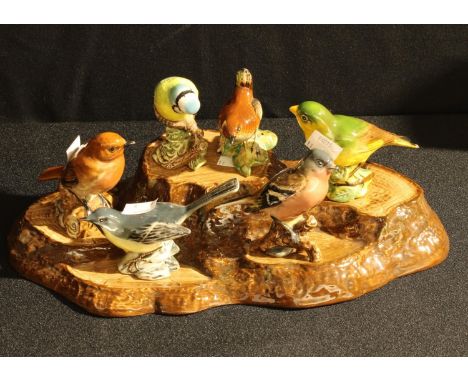 A set of six Beswick bird models, Robin, Chaffinch, Blue Tit, Grey Wagtail, Greenfinch and Wren; a ceramic stand as a tree st