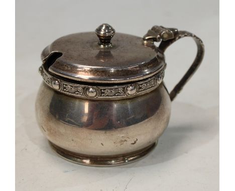 A silver Celtic band mustard pot and cover with acanthus loop handle, Birmingham 1954 