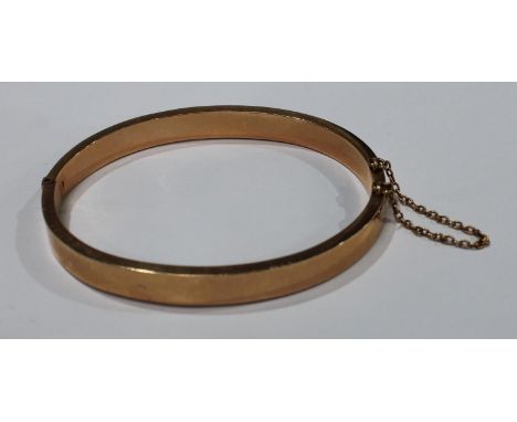 A 15ct gold hinged bangle, of plain design, safety chain, 13.2g 